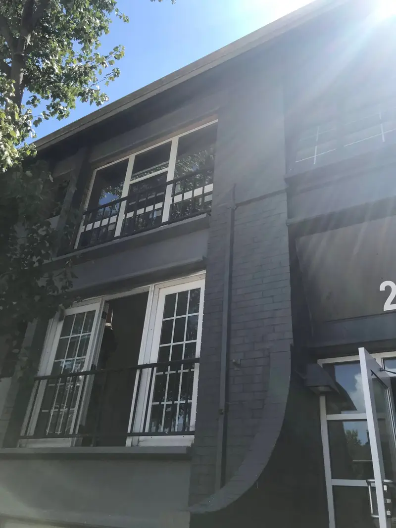 Gray brick commercial building exterior with restored masonry and railings
